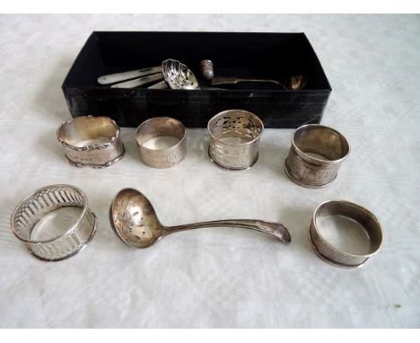 A mixed lot to include: a group of silver napkin rings, mother of pearl handled fruit knives, thimbles and other items.