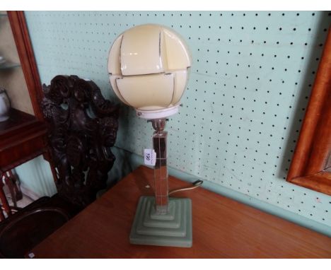 An Art Deco-style table lamp, having geometric shaped globe, over a column inset with reflective glass on a stepped square ba