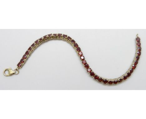 A silver gilt tennis bracelet set with garnets 