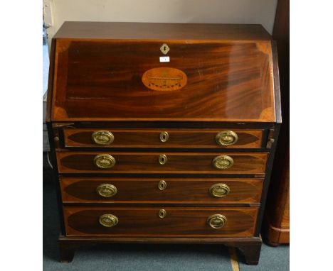 An Edwardian mahogany bureau the fall front fitted with an arrangement of pigeon-holes and drawers above four long graduated 