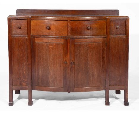 A Heals oak sideboard circa 1920 with bow front and four short drawers over a central cupboard section, all with turned knob 