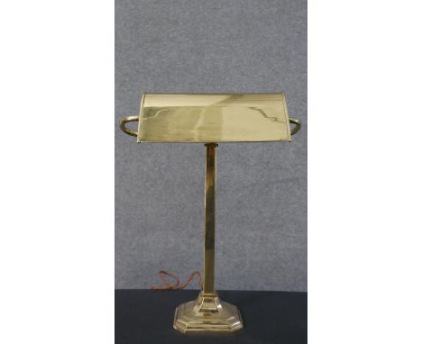 An early 20th century brass bankers lamp, with an adjustable shade on a square step down base. H.41 W.31cm 