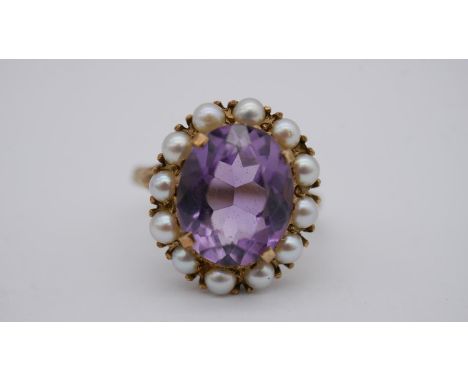 A Victorian 9 carat yellow gold amethyst and cultured pearl cluster ring. Set to centre with an oval mixed cut amethyst with 