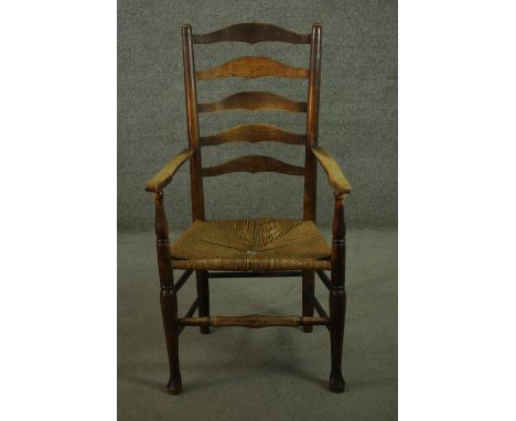 A 19th century ash ladder back open armchair, with a woven seat, on turned legs, joined by stretchers. 