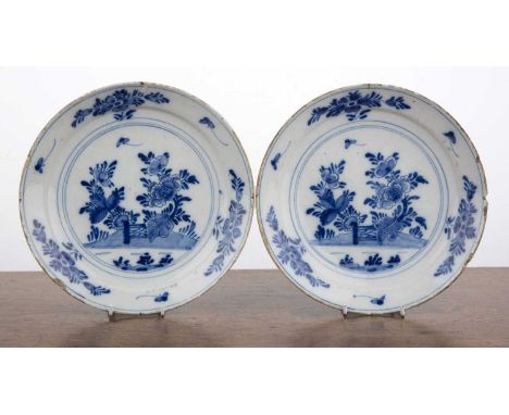 Pair of blue and white Delft plates18th Century, each decorated with flowers, a hill and a gate to the centre, 22cm diameter 