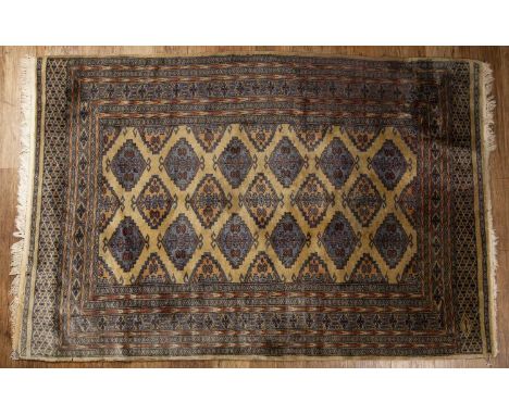 Pakistan Bokahara pattern rugof gold ground with multiple borders, 124cm x 88cm  Some losses to the fringe and light wear.