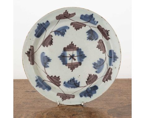 Delftware plate18th Century, painted in manganese and blue, 22cm diameter  With some chips and scratches.