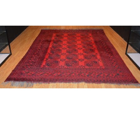 A Persian style carpet, decorated with seven rows of three black octagonal motifs on red ground, 346 x 260cm