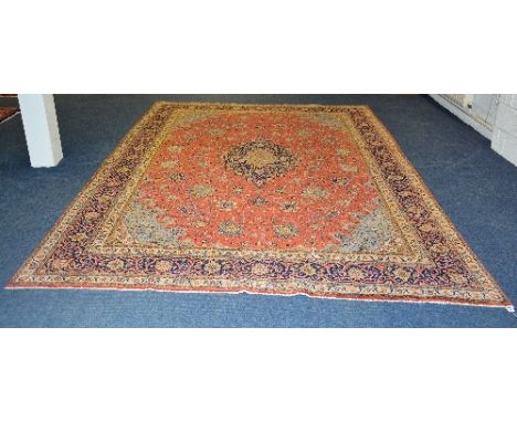 A Sarough carpet, the large multi-coloured floral motif on red floral ground, with blue and cream floral border, 384 x 272cm
