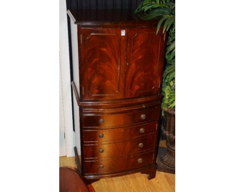 A reproduction display cabinet on chest, with two panelled doors enclosing shelved interior with glass back plate and electri