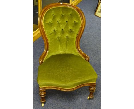 A Victorian lady's walnut armchair, upholstered in green buttonback velour, with serpentine front raised on turned supports w