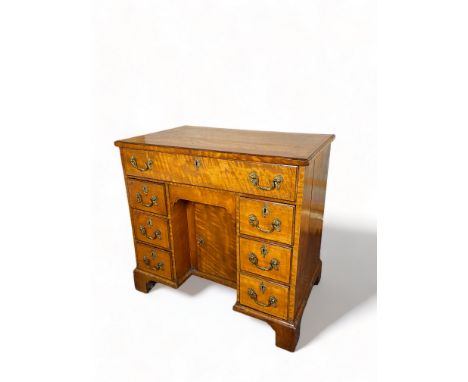 A George III satinwood kneehole desk
Inlaid with boxwood lines, the rectangular top above a frieze drawer fitted with divisio