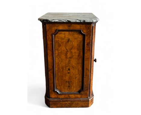 A Victorian burr walnut marble topped pot cupboard
The grey and black veined marble top above a panelled door enclosing a she