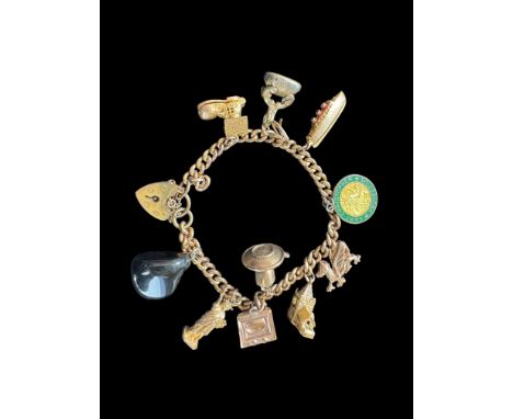 A 9ct gold curblink bracelet with 9ct gold heart padlock clasp and hung with ten charms, 1960s
Comprising of a polished grey 