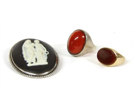 A 9ct gold cornelian signet ring, with an oval cornelian tablet, rub set in landscape orientation, to tapered shoulders and a