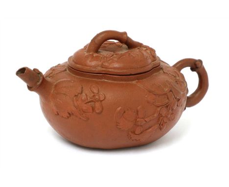 A Chinese yixing teapot, of oval form, moulded with sprigs of flowers, the cover similarly decorated, 14cm long