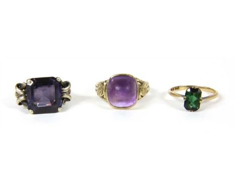 A 9ct gold amethyst ring, with a cabochon amethyst rub set to tapering shoulders with scroll decoration and a plain shank, 5.