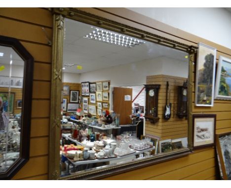 A large bevelled wall mirror in a Classical architectural gilded frame