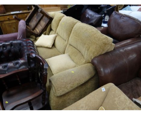 A modern three-seater sofa upholstered in an oatmeal coloured fabric