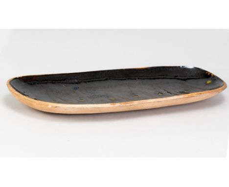 MICHAEL LEACH (1913-1985) for Yelland Pottery; a long earthenware dish with green decoration on tenmoku ground, impressed pot