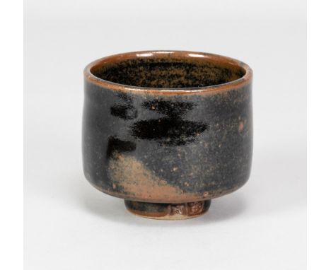 NIC HARRISON (born 1949) for Leach Pottery; a stoneware yunomi covered in tenmoku breaking to kaki glaze, impressed N and pot