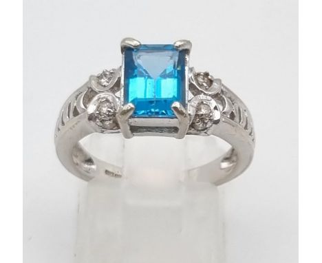A 9K White Gold Topaz Diamond Ring. Central topaz with two diamonds either side. 1ct - topaz. .2ct - diamond. Size N. 4g tota