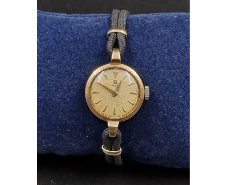 A Vintage 9K Yellow Gold Ladies Omega Watch. 9K yellow Gold part-strap and case - 20mm. Gold dial. Mechanical movement. In wo