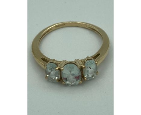 9 carat GOLD RING having  three Quartz Aqua gemstones mounted to top in trilogy setting. Complete with ring box.1.95 grams. S