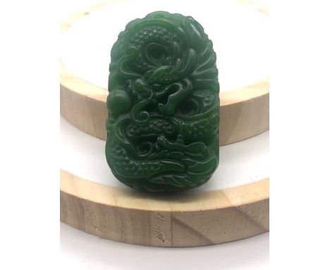 A Green Jade Dragon-Image Carved Pendant. 5cm. 