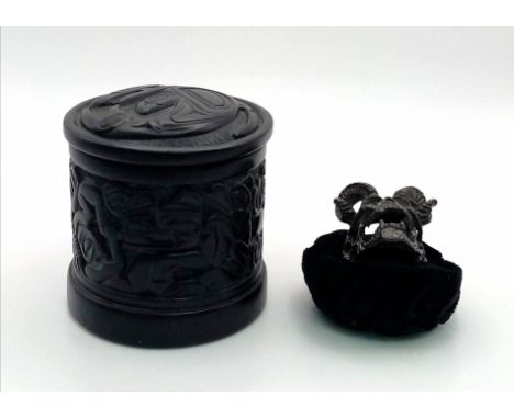 An unusual white metal (untested) with a black patina gents ring, depicting a human skull with ram’s horns.Presented in a Can