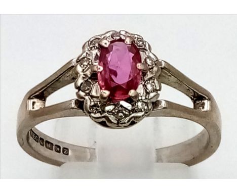 A Vintage 18K White Gold Natural Burmese Ruby and Diamond Ring. Central ruby surrounded with a halo of diamonds. Size O. 4.63