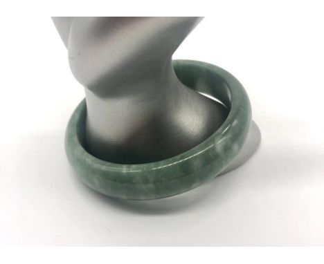A Green Jade Bangle (white swirls). 6cm inner diameter. 