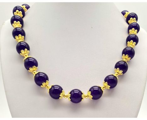 A Purple Jade Beaded Necklace. Gilded spacers and clasp. Beads - 12mm. 44cm. 