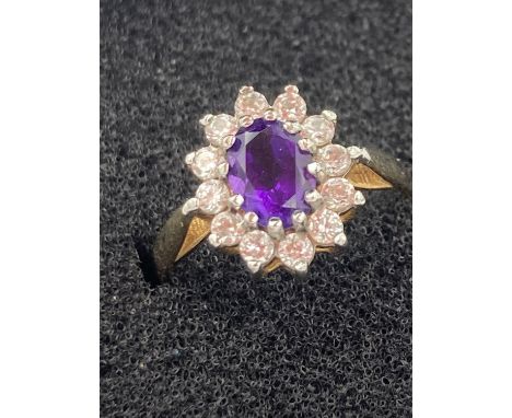 9 carat yellow GOLD RING having Amethyst centre with clear zirconia surround. 2.1 grams. Size M. 