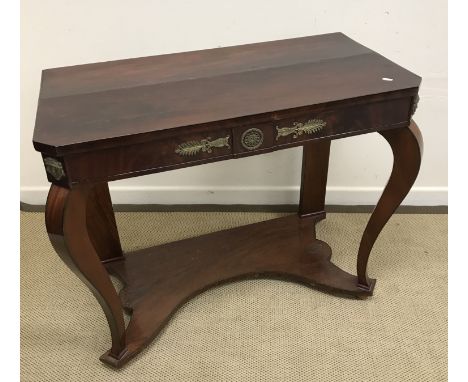 A mahogany console table in the 19th Century French Empire taste, the plain top over a frieze decorated with brass foliate me