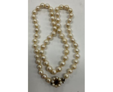 An early 20th Century cultured pearl single strand necklace with 9 carat gold mounted garnet and seed pearl clasp, 47 cm long