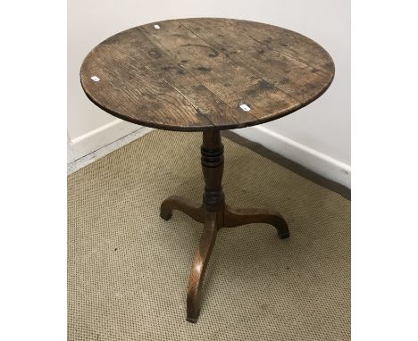 An early 19th Century oak occasional table, the circular top on a turned and ringed pedestal to splayed tripod base and block