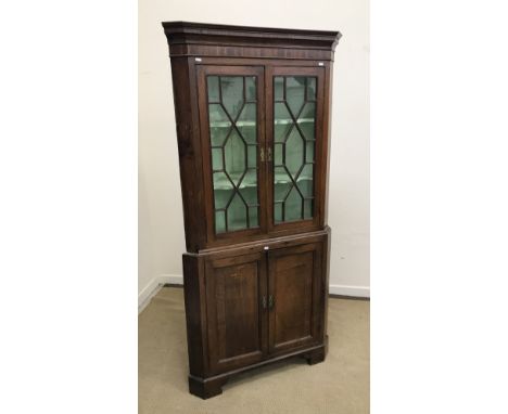 A 19th Century oak and inlaid free-standing corner cabinet, the moulded cornice over a parquetry work frieze and two astragal