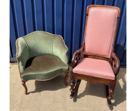 A Victorian mahogany framed rocking armchair with upholstered back panel and seat, flanked by scroll arms, on turned legs to 