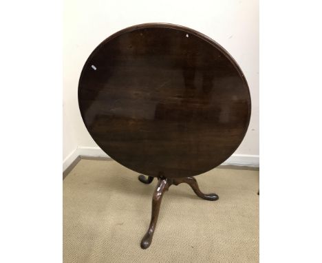 A 19th Century mahogany tea table, the circular snap top with moulded edge tipping on a birdcage, raised on a baluster turned