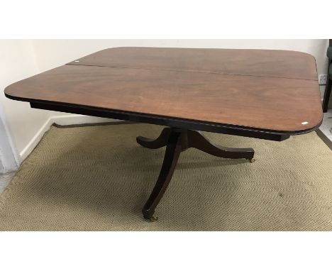 An early 19th Century mahogany breakfast table, the rounded rectangular snap top (presently fixed) on a turned pedestal to sp
