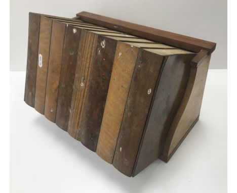 A circa 1900 sample wood box as a trough of eight books, 34.5 cm wide x 23.5 cm high