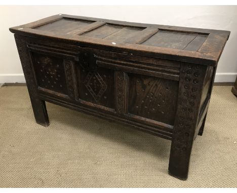 A circa 1700 oak coffer, the plain three panelled top on ring hinges, over a small circular medallion decorated front of thre
