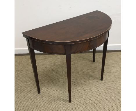 An early 19th Century mahogany and satinwood strung foldover card table of demilune form opening to reveal a green baize line