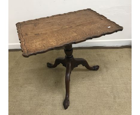 A 19th Century oak pedestal occasional table, the rectangular top with pie-crust edge, raised on a carved tripod base to exag