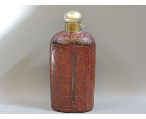 A large glass spirit flask, circa 1900, with silver plated mount encased in alligator skin