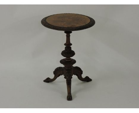 A Victorian walnut tripod table, the inlaid top with a bas carved border on a carved base