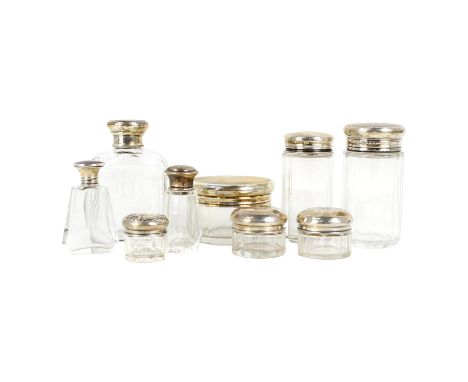 A silver mounted faceted clear glass dressing case bottle - with engine turned cover, together with eight other bottles and c