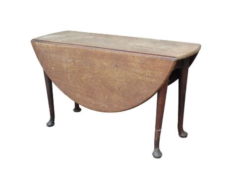 A George III mahogany drop leaf table - the oval top above a gate leg action and turned tapering legs ending in pad feet, wid