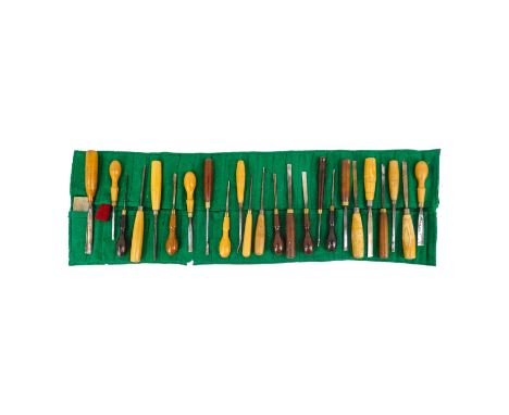 Twenty four 20th century carving chisels - in a green baize tool roll, together with two Arkansas stones.